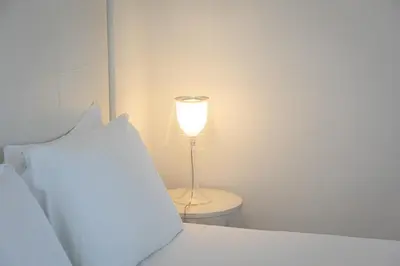 a lamp sitting on a table next to a bed at Amazing Cozy Piazza Venezia in Rome