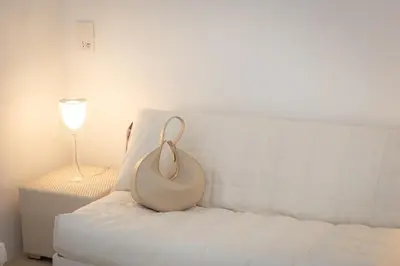 a white couch with a vase on it next to a lamp at Amazing Cozy Piazza Venezia in Rome