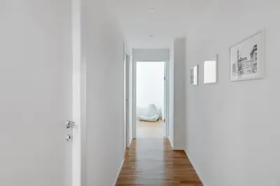 an empty hallway with white walls and wooden floors at GIULIANA Boutique Apartment in Rome