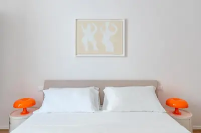 a bedroom with a white bed with orange accents at GIULIANA Boutique Apartment in Rome