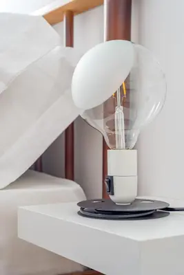 a light on a table with a cup on it at GIULIANA Boutique Apartment in Rome