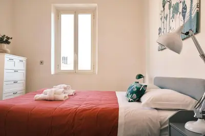 a bedroom with a bed with a red blanket and a window at Carolina Trastevere House in Rome