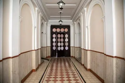 an empty hallway with a black door and a checkered floor at NINFA in Rome