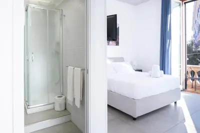a white bedroom with a bed and a shower at Élite Vatican Refuge in Rome