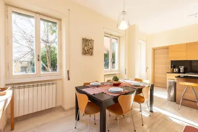 a kitchen and dining room with a table and chairs at Trastevere Garden by Rental in Rome in Rome