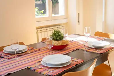 a dining room table with plates and wine glasses at Trastevere Garden by Rental in Rome in Rome