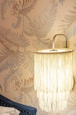 a lamp hanging from a wall with a leafy wallpaper at YCH-Cozy Flat at the Vatican in Rome