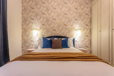 a bedroom with a large bed with blue pillows at YCH-Cozy Flat at the Vatican in Rome