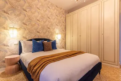 a bedroom with a large bed with blue pillows at YCH-Cozy Flat at the Vatican in Rome