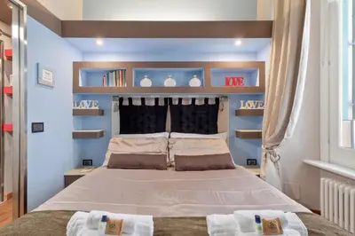 a bedroom with a bed with blue walls and shelves at Rome as you feel - Casa Governo Vecchio in Rome