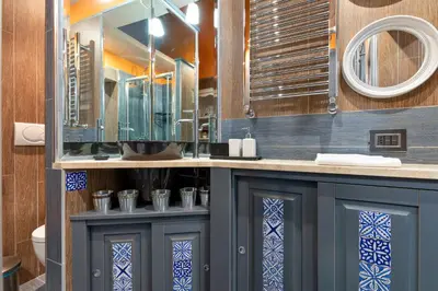 a bathroom with a blue cabinet and a mirror at Rome as you feel - Casa Governo Vecchio in Rome