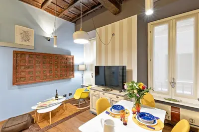 a living room with a table and chairs and a television at Rome as you feel - Casa Governo Vecchio in Rome