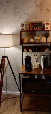 a room with a table with a lamp and a shelf with dishes at Afnakafna Home in Rome