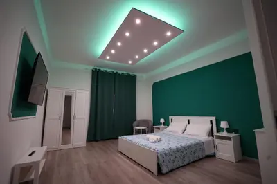 a bedroom with a bed and a green wall at House Appio Latino Roma in Rome