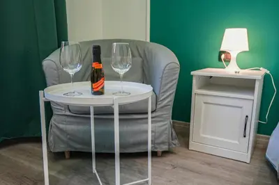 a bottle of wine on a table next to a chair at House Appio Latino Roma in Rome