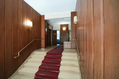 a hallway with wooden walls and stairs with red carpet at House Appio Latino Roma in Rome