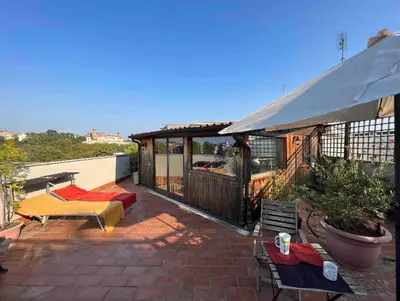 a patio with a building with a table and chairs at Chalet dei Girasoli in Rome