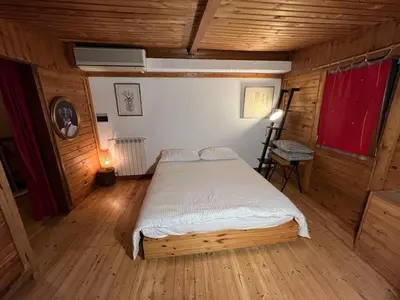 a bedroom with a bed in a room with wooden floors at Chalet dei Girasoli in Rome