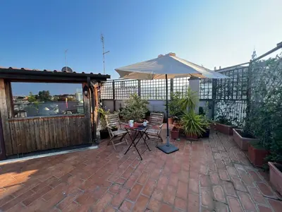a patio with an umbrella and a table and chairs at Chalet dei Girasoli in Rome