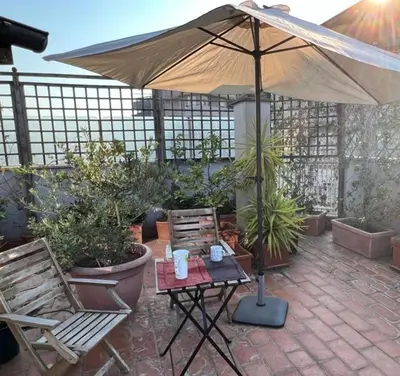 a patio with an umbrella and a table and chairs at Chalet dei Girasoli in Rome