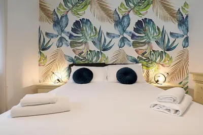 a bedroom with a large bed with a floral wall at Piramide - Charme Apartment in Rome