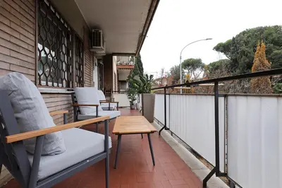 a balcony with chairs and a table on a building at Piramide - Charme Apartment in Rome