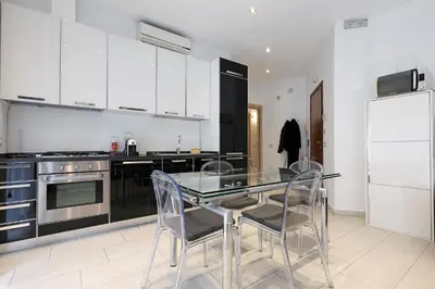 a kitchen with a glass table and chairs and a refrigerator at Piramide - Charme Apartment in Rome