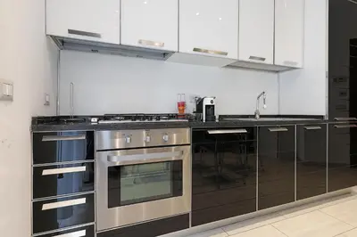 a kitchen with stainless steel appliances and black and white cabinets at Piramide - Charme Apartment in Rome