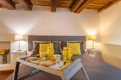 a room with a bed with a tray of food on it at L'antico borgo di Trastevere III in Rome