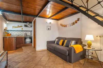a living room with a couch and a kitchen at L'antico borgo di Trastevere III in Rome