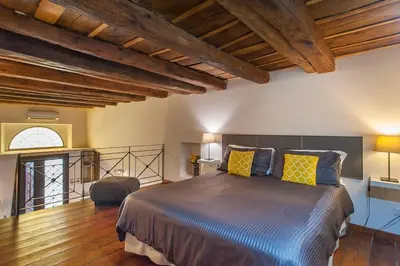 a bedroom with a large bed with yellow pillows at L'antico borgo di Trastevere III in Rome