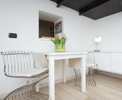 a white table and a bench with a table and flowers at HT Loft Testaccio in Rome