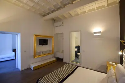 a bedroom with a large bed and a mirror at Navona Secret Stay Guest House in Rome