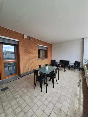 a patio with a table and chairs and a brick wall at Angy's house Roma in Rome