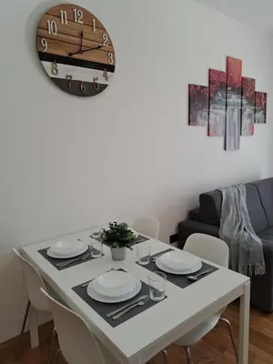 a dining room table with plates and a clock on the wall at Angy's house Roma in Rome