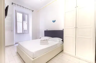 a white bedroom with a bed and a window at Cairoli 2 House G&B Termini in Rome