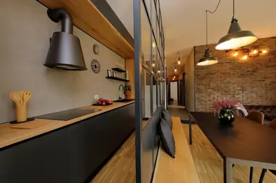 a kitchen with black cabinets and a dining table at YCH-Trilocale stile Industriale in Rome