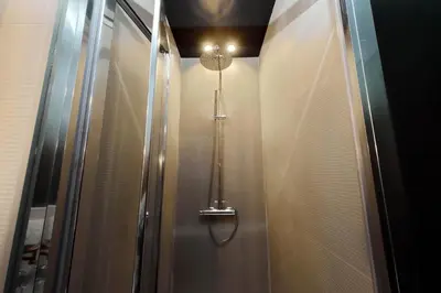 a walk in shower with a light on the wall at YCH-Trilocale stile Industriale in Rome