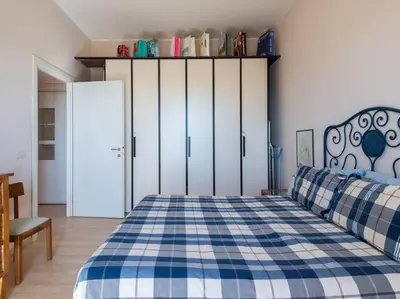 a bedroom with a bed with a blue and white checkered blanket at Bright Panorama Apartment in Rome
