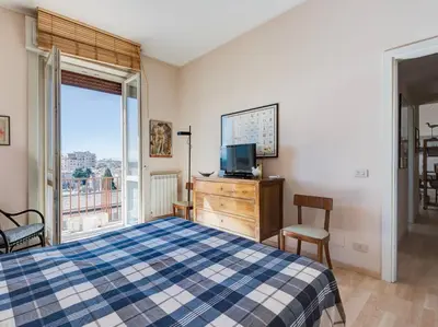 a bedroom with a bed and a tv and a window at Bright Panorama Apartment in Rome