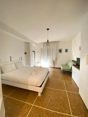 a white bedroom with a bed and a couch at La Piccoletta di Garbatella in Rome