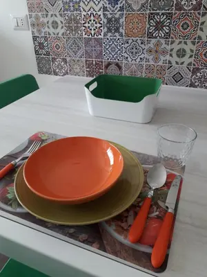 an orange plate on a tray with utensils on a counter at La Piccoletta di Garbatella in Rome