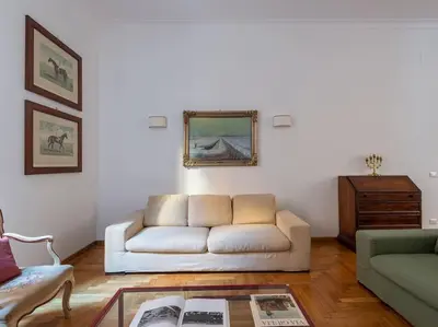 a living room with a white couch and a table at Giulia Luxury Two Bedroom Apartment in Rome