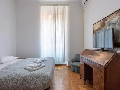 a bedroom with a bed and a flat screen tv at Giulia Luxury Two Bedroom Apartment in Rome