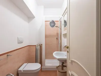 a small bathroom with a toilet and a sink at Giulia Luxury Two Bedroom Apartment in Rome