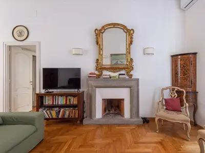 a living room with a fireplace and a mirror at Giulia Luxury Two Bedroom Apartment in Rome