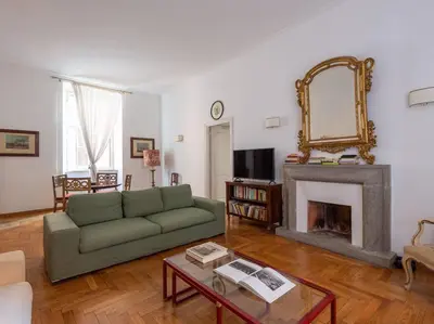 a living room with a green couch and a fireplace at Giulia Luxury Two Bedroom Apartment in Rome