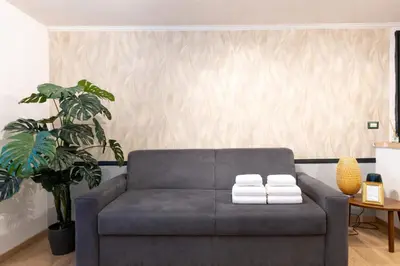 a living room with a couch with two towels at Arya Roma Vaticano in Rome