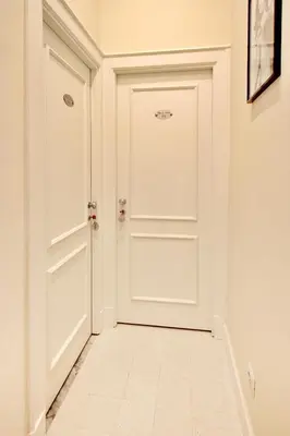 a white door in a hallway with a tile floor at Dreaming Rome Suites in Rome