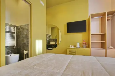 a bedroom with a large bed and a tv on the wall at Dreaming Rome Suites in Rome